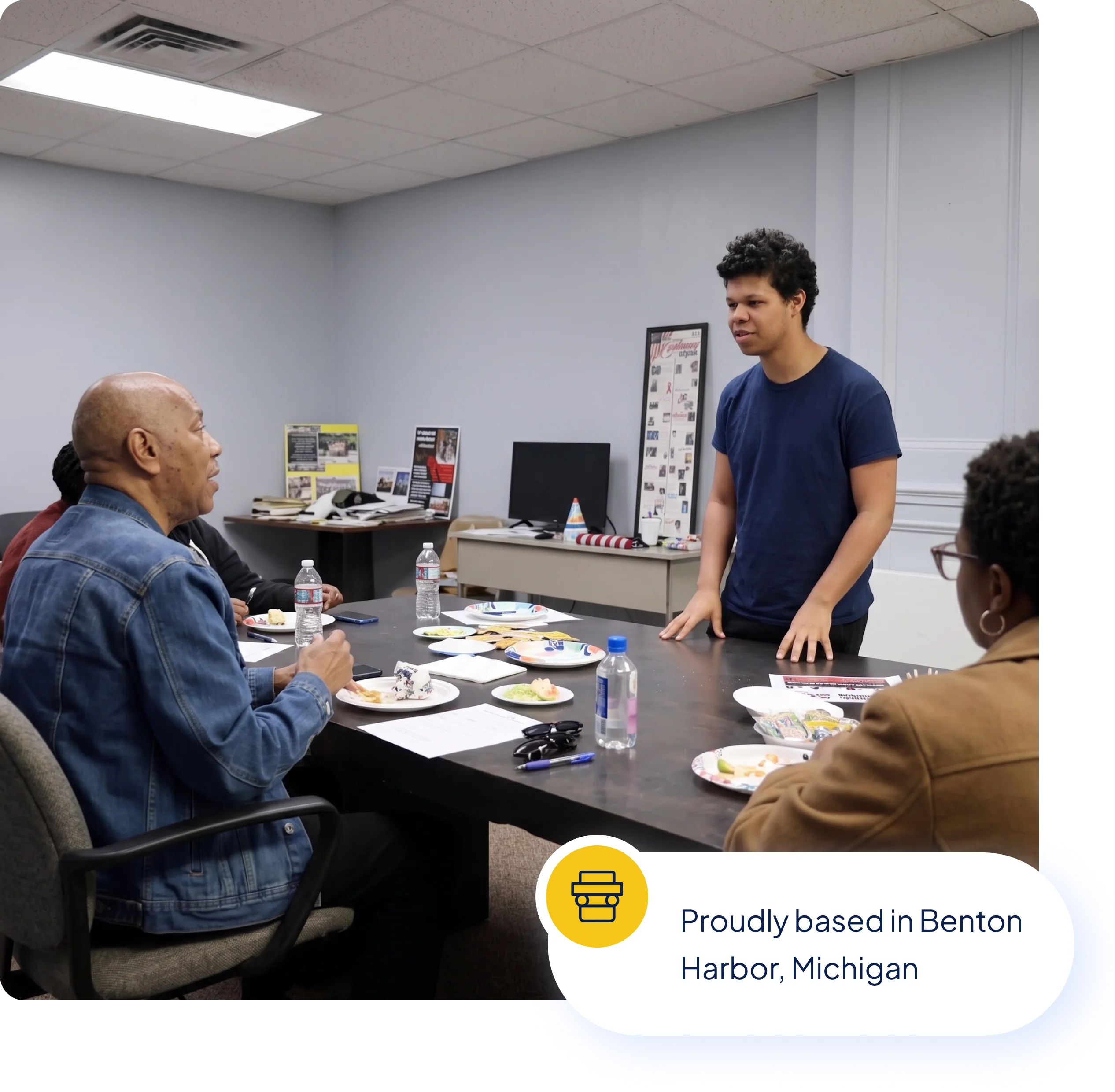 A Berrien Connection staff member speaking with residents around a table at the Benton Harbor office