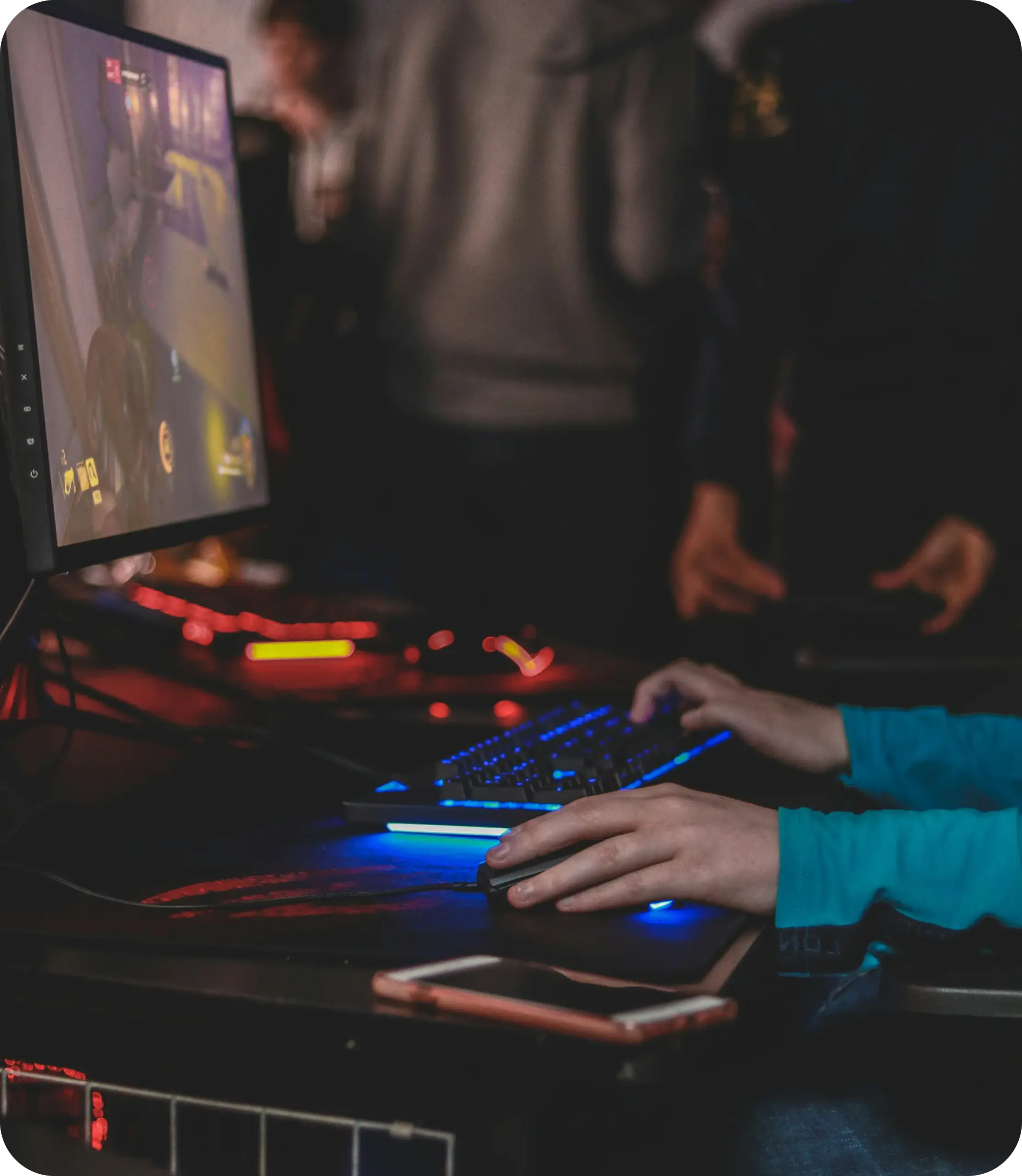A player at a backlit keyboard and mouse at an esports setup